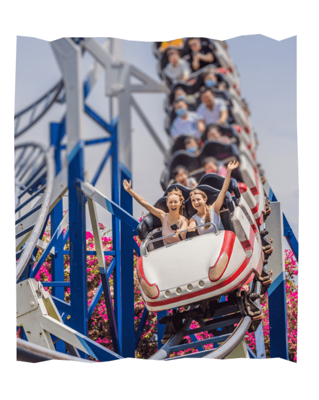 Mehrere Menschen, die gerade auf einer Achterbahn im Hansa-Park durch eine Kurve fahren.