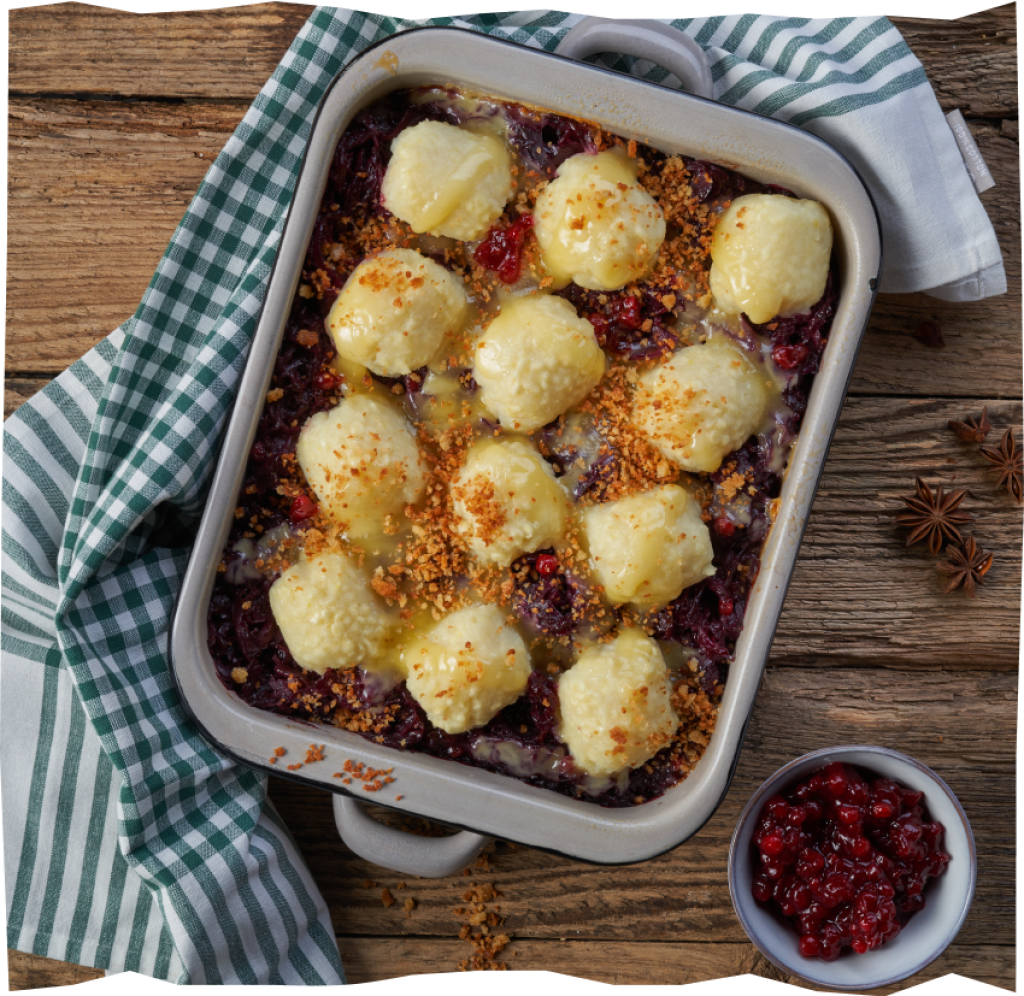 Jnusprige Mini-Kartoffelklöße, geschmorter Rotkohl und würziger Raclette-Käse in einer Auflaufform.