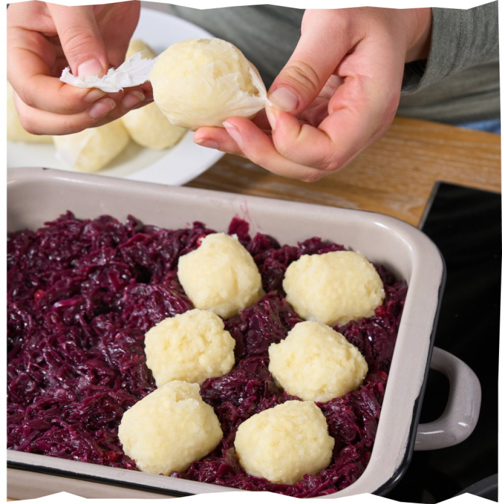 Mini-Kartoffelklößen von Echt vom Feld in einer Auflaufform, auf Rotkohl gebettet.
