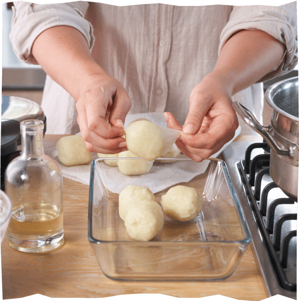 Zubereitung von Mini-Kartoffelklößen auf Anrichte aus Holz.