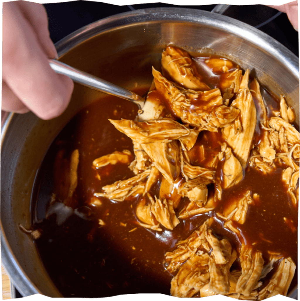 Feingezupftes Hähnchenbrustfilet mit Barbeque-Soße vermengt.