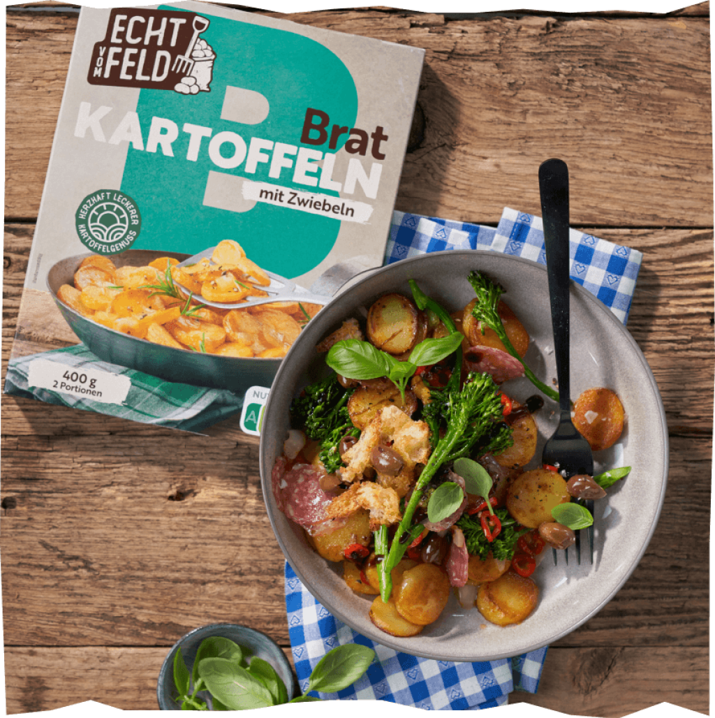 Echt vom Feld Bratkartoffelsalat auf Holztisch und kariertem Spültuch.
