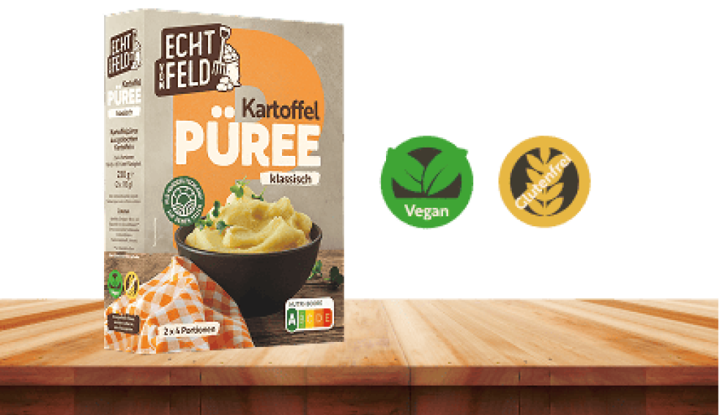 Klassisches Kartoffelpüree von Echt vom Feld auf einem Holztisch. Daneben Symbole für vegan und glutenfrei.