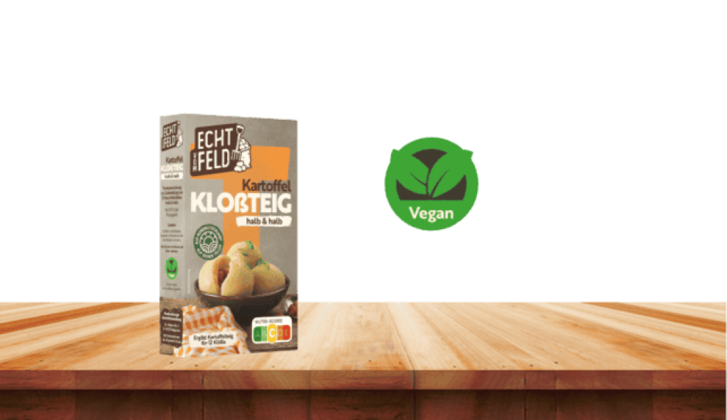 Eine Packung Echt vom Feld Kloßteig auf einem Holzbrett. Danebn ein Symbol, das auf die veganen Zutaten hinweist.