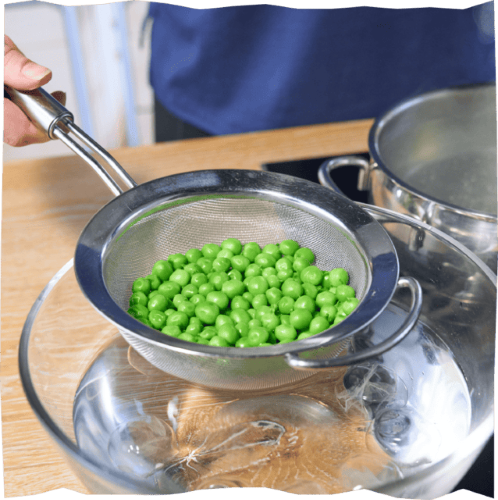 Erbsen in kochendem Wasser blanchieren für einen leckeren Green Goddess Salat.