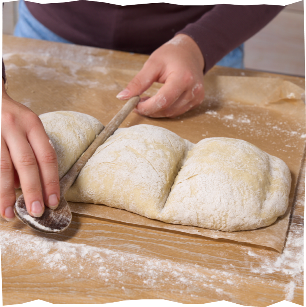 Teig in Handbrot-taugliche Größen mithilfe eines Holzlöffels unterteilen.