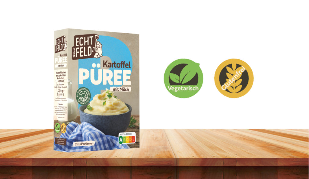 Eine Packung Echt vom Feld Kartoffelpüree auf einem Holzbrett. Daneben zwei Symbole für vegetarisch und glutenfrei.