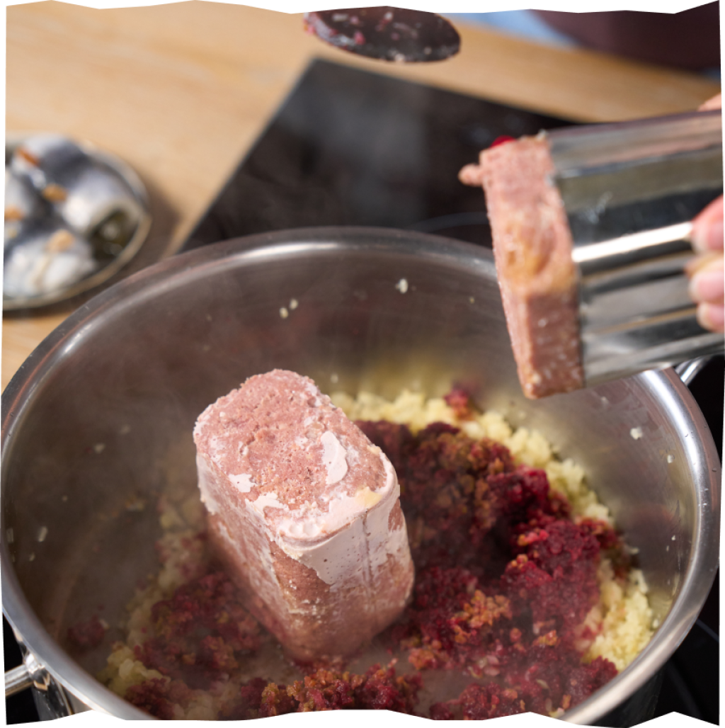 Corned Beef, Gurken, Rote Beete und Zwiebeln beim Schmoren in einem Topf.