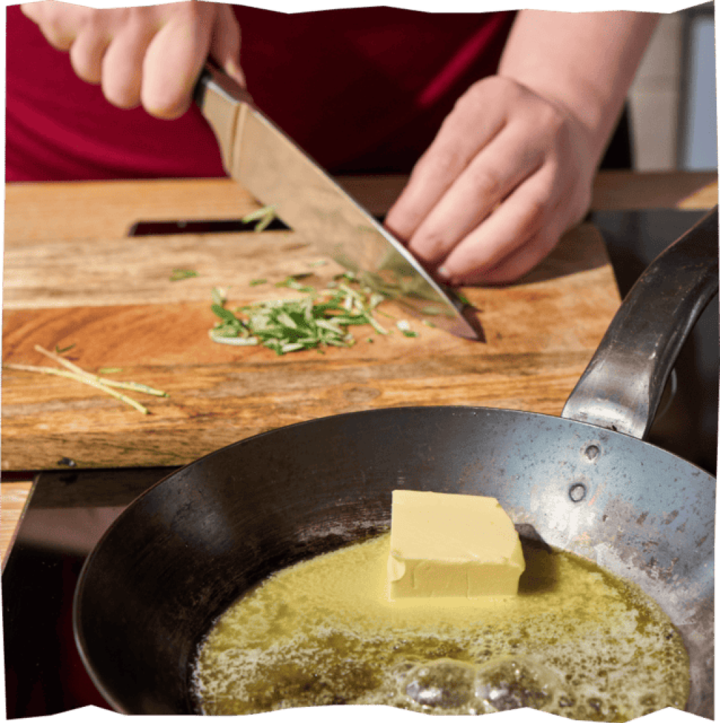 Hände hacken Rosmarinnadeln mit Messer, daneben zerlassene Butter in einer Pfanne.