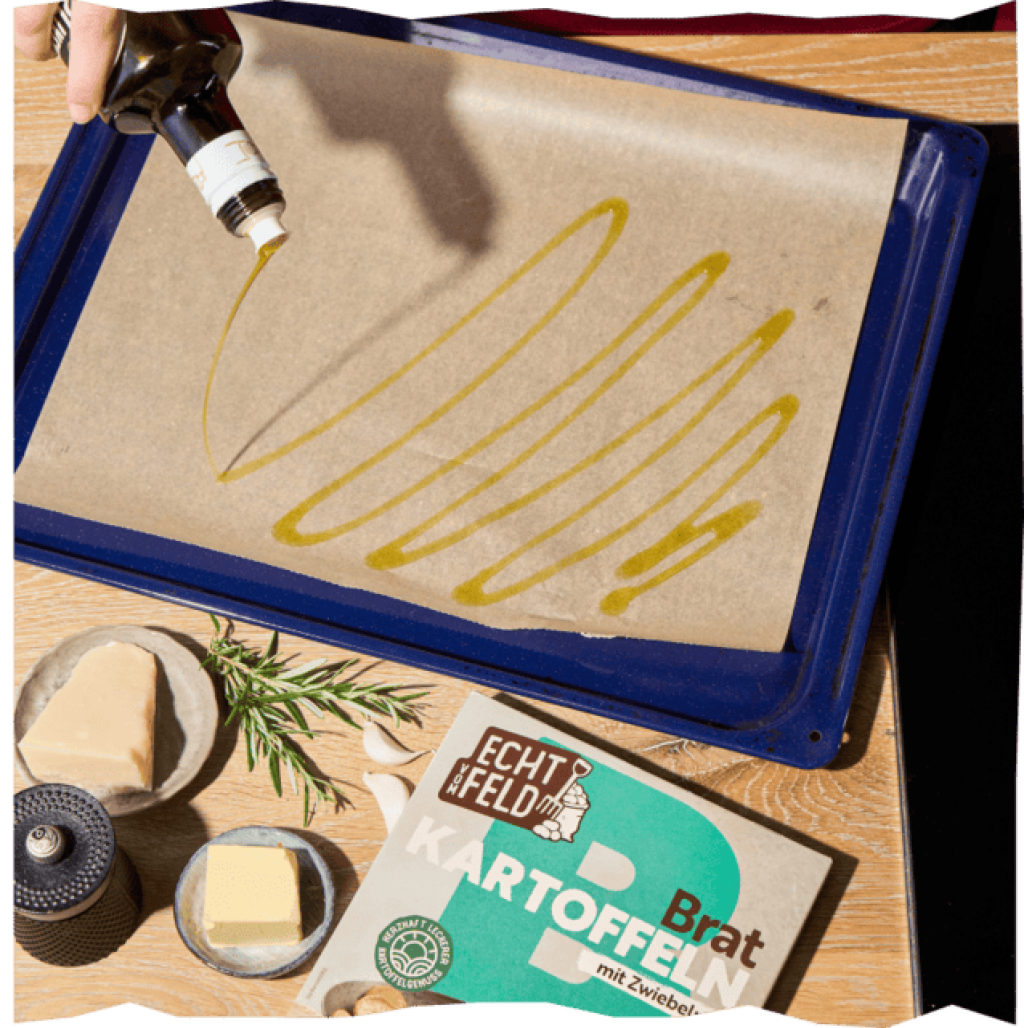 Backblech mit Backpapier, darauf Olivenöl, nebenan Kartoffeln, frischer Rosmarin und Butter.