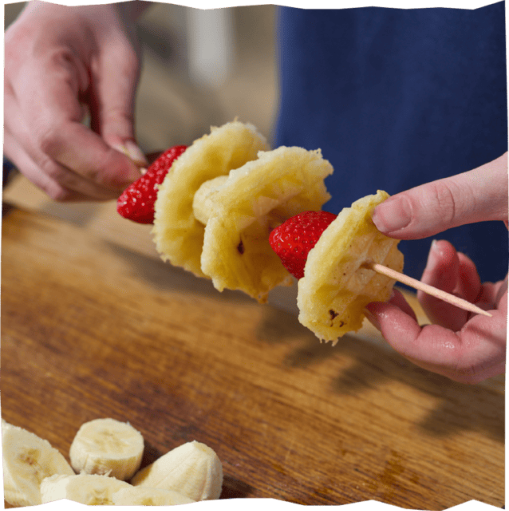 Waffelklöße mit Früchten auf Holzspießen.