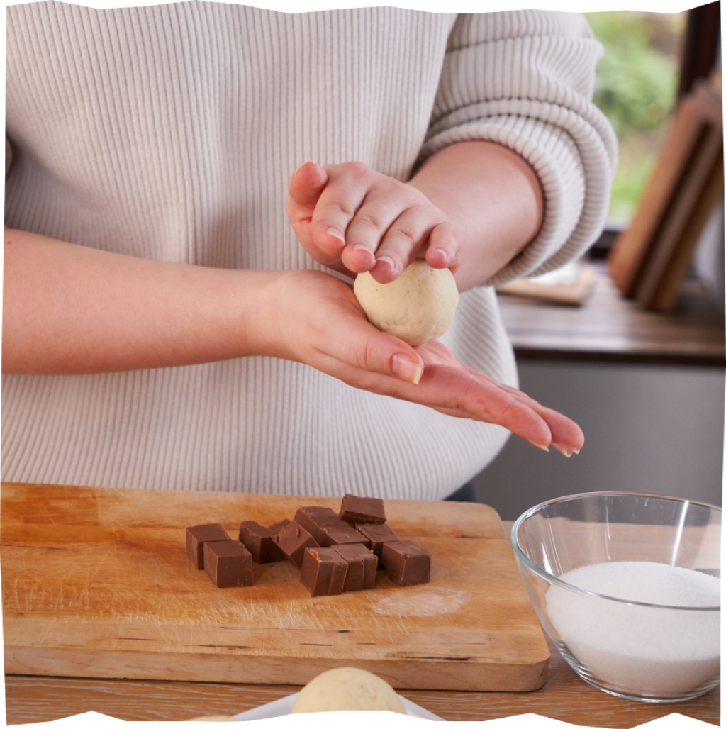 Zubereitung von Nougat-Klößen aus Nougat, Kloßteig und Zucker.